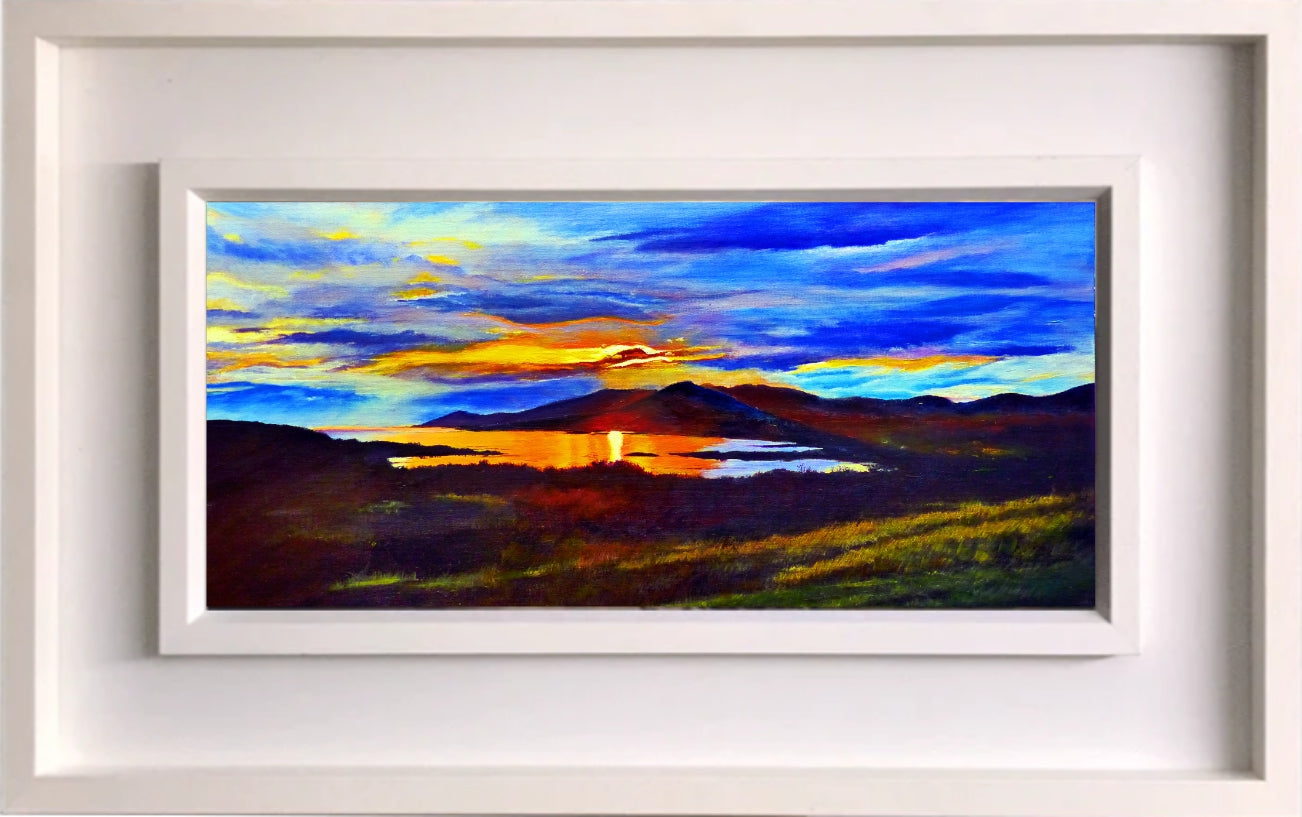 Framed painting of a sunset over a lake with colorful sky and landscape.