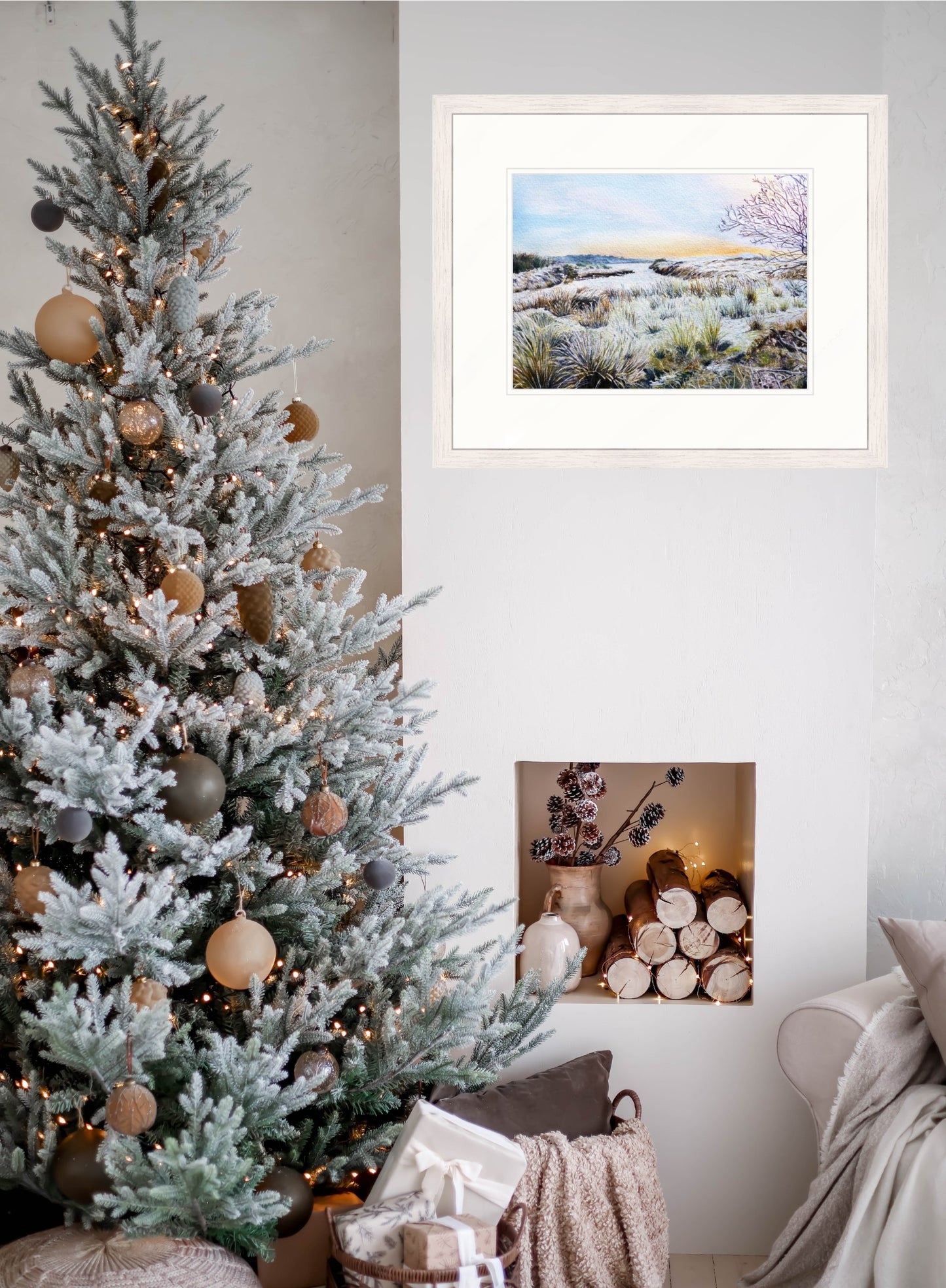 Decorated Christmas tree with ornaments next to a framed original winter painting on a wall.