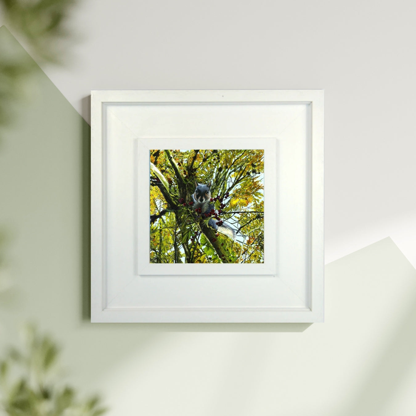Framed artwork of a tree with leaves on a white wall